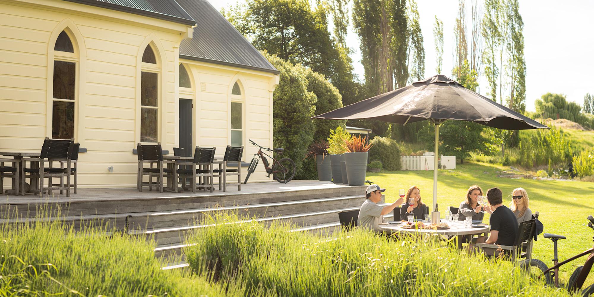 Guests enjoying New Zealand wine and local produce at a vineyard in Gibbston Valley near Queenstown in the South Island